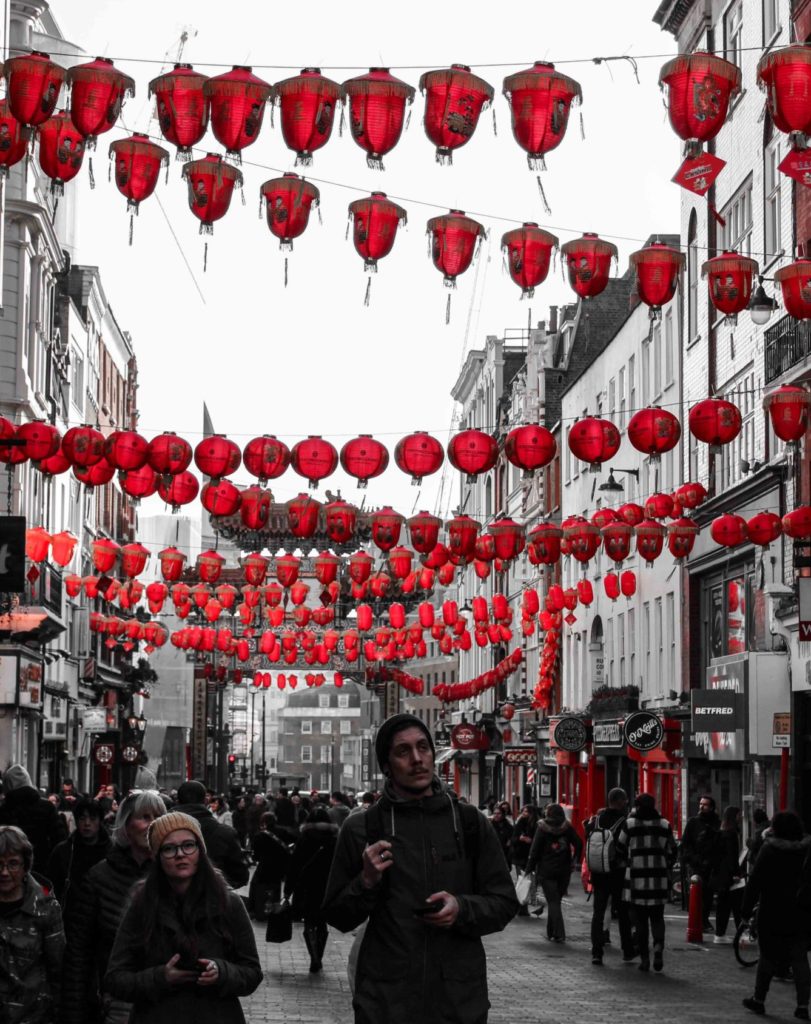 man walking down the street with Chinese lanterns